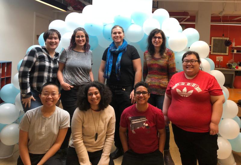 The eight current members of the Palante team standing in front of a balloon arch at the winter 2020 retreat